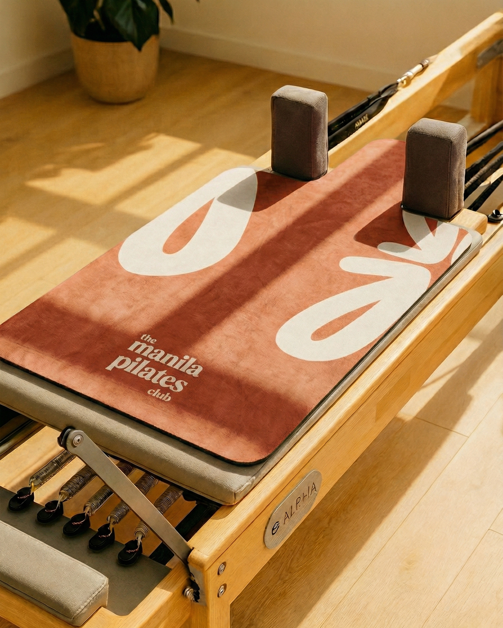 The Classic Reformer Mat in terracotta on a Pilates reformer, suede Pilates reformer mat by Tuelles